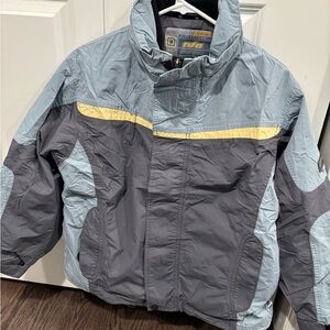 Ultrastorm NFA Women's Ski Jacket in Gray and Light Blue with Yellow Stripe.